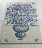 An antique vase with flowers.  Bathroom tile mosaic/Kitchen backsplash.